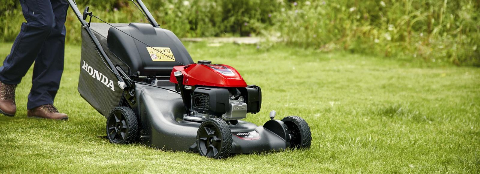 Homme qui tond son jardin avec une tondeuse thermique Honda HRN 536